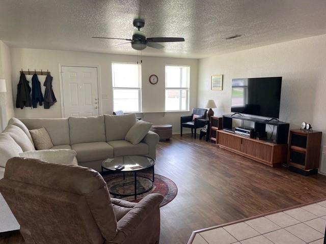 living area with visible vents, ceiling fan, a textured ceiling, and wood finished floors
