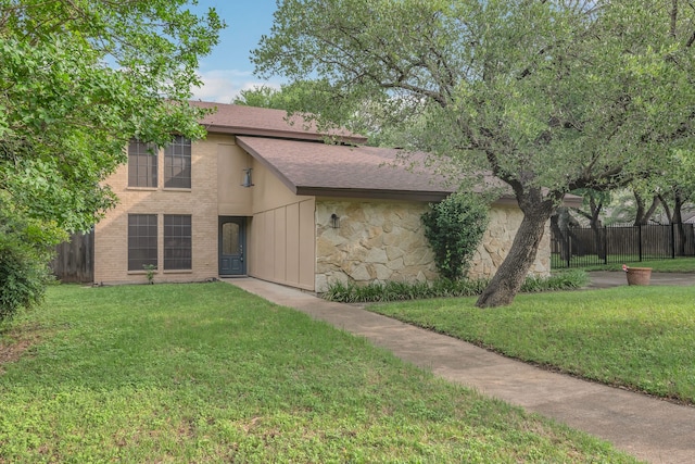 7804 Skylake Dr, Fort Worth, TX 76179 - view of front facade with brick siding, roof with shingles, fence, and a front yard