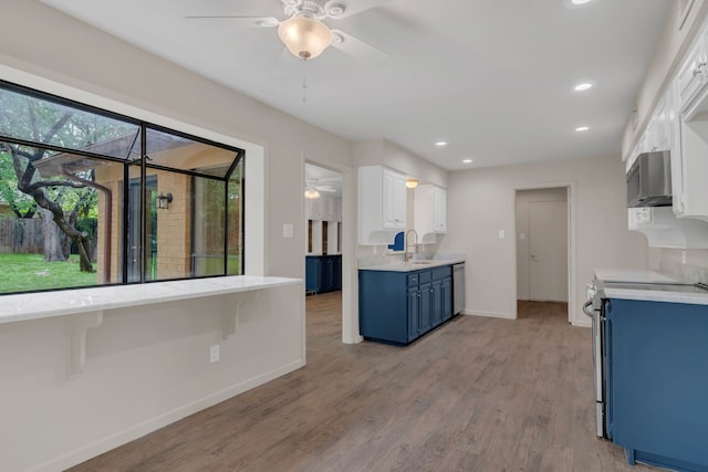 7804 Skylake Dr, Fort Worth, TX 76179 - kitchen with a ceiling fan, blue cabinetry, light countertops, baseboards, and stainless steel appliances
