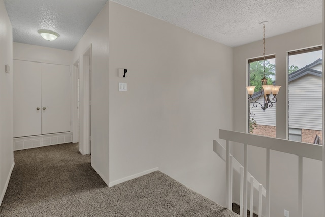 7804 Skylake Dr, Fort Worth, TX 76179 - corridor featuring baseboards, a textured ceiling, a chandelier, carpet, and an upstairs landing