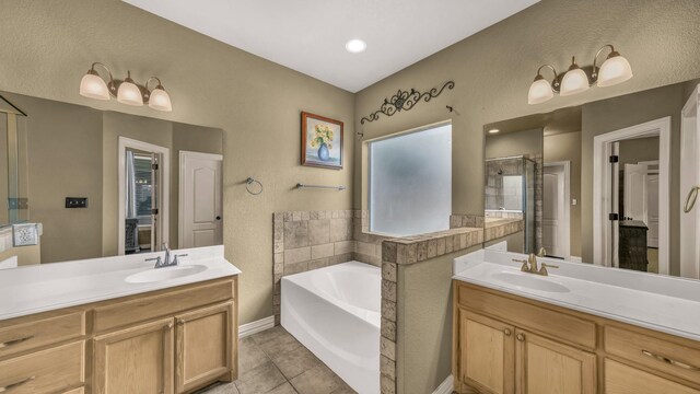 1821 Sandpiper Dr, Weatherford, TX 76088 - full bathroom featuring a stall shower, a garden tub, two vanities, baseboards, and a textured wall
