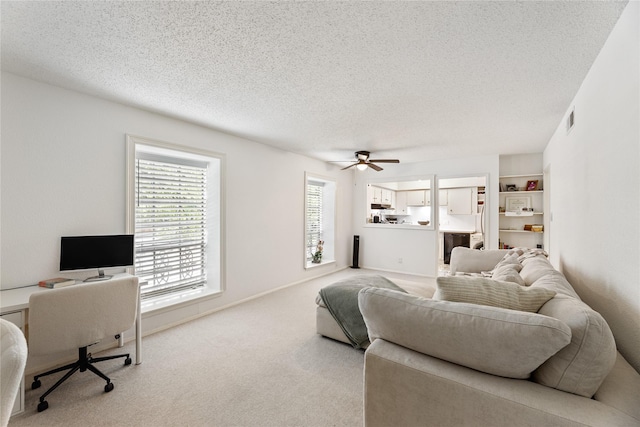 carpeted living area featuring ceiling fan, a textured ceiling, and visible vents