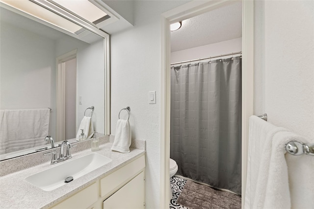 bathroom with toilet, a shower with curtain, a textured ceiling, and vanity