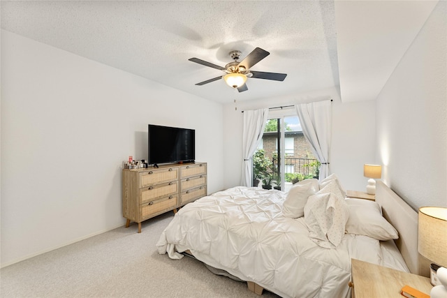 bedroom featuring a ceiling fan, a textured ceiling, access to exterior, baseboards, and light carpet