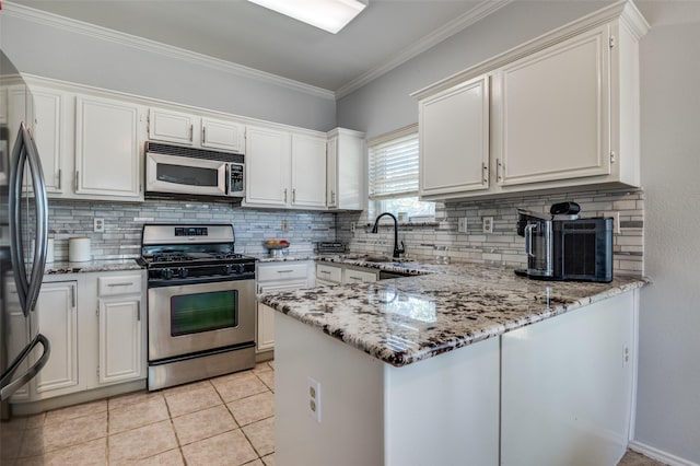 1521 Merritt Dr, Flower Mound, TX 75028 - kitchen featuring stainless steel appliances, a sink, tasteful backsplash, a peninsula, and white cabinetry