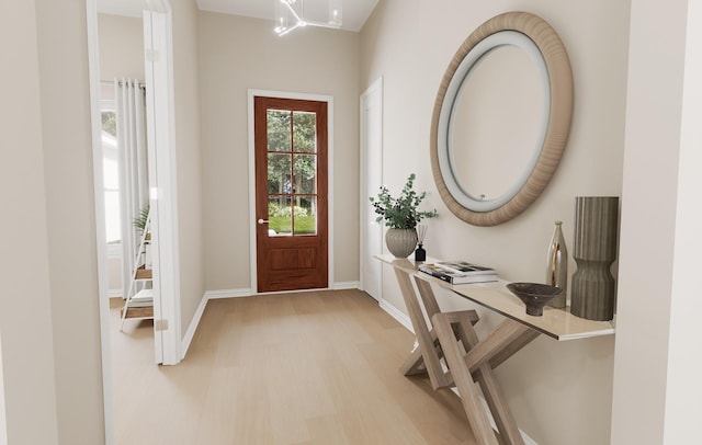foyer with baseboards, light wood-style flooring, and an inviting chandelier