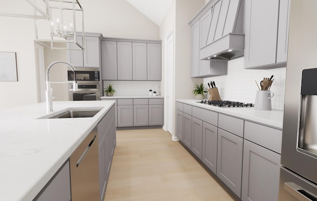 kitchen with a sink, appliances with stainless steel finishes, custom exhaust hood, and gray cabinetry