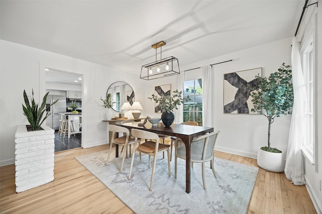 dining room with light wood-style floors and baseboards