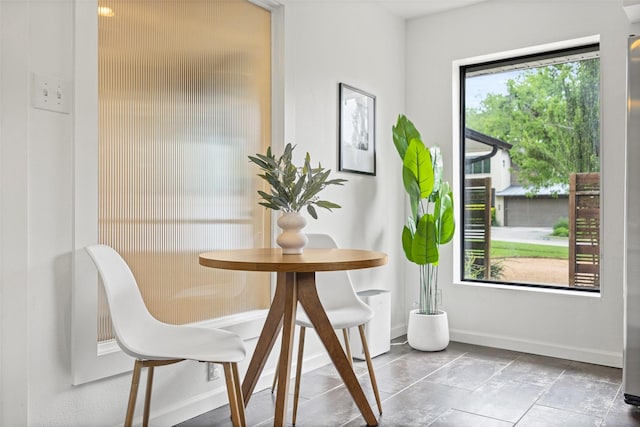 dining space with baseboards and stone finish floor
