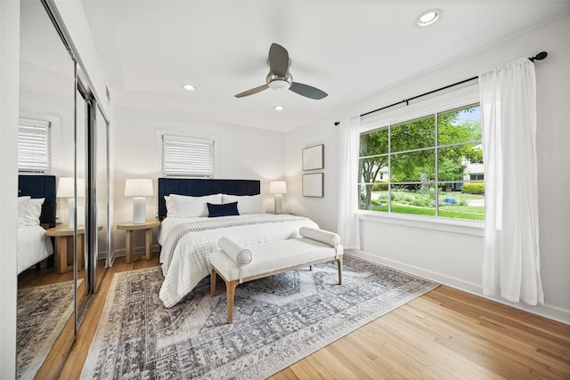 bedroom featuring a closet, wood finished floors, baseboards, recessed lighting, and a ceiling fan
