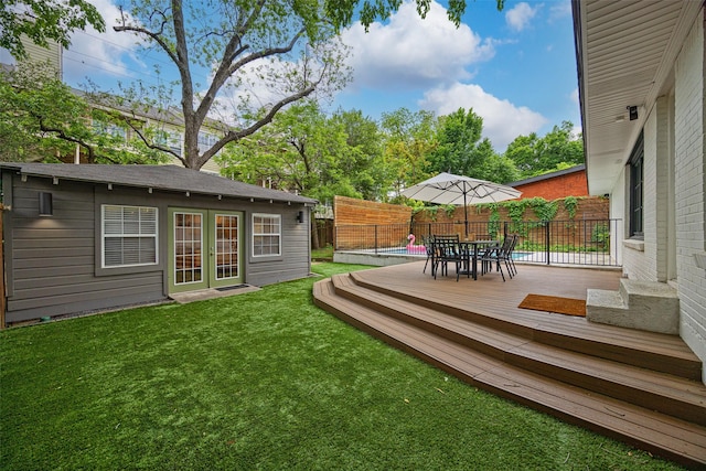 view of yard featuring fence, outdoor dining area, and a deck