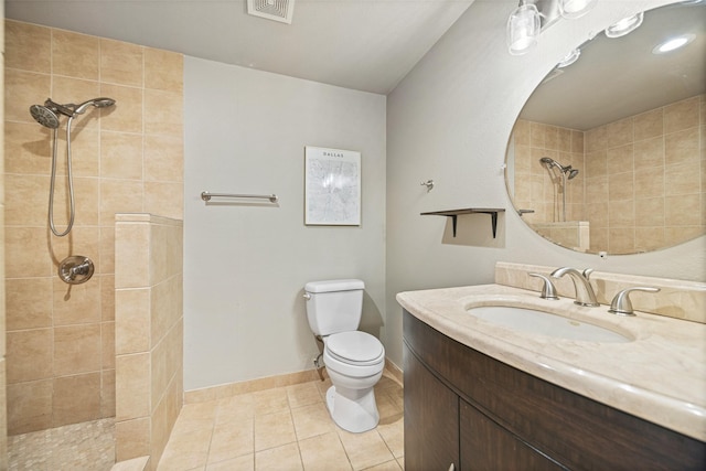 bathroom featuring visible vents, vanity, toilet, tiled shower, and tile patterned floors