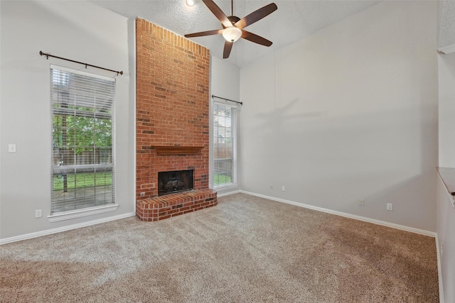 unfurnished living room with a brick fireplace, carpet, ceiling fan, and baseboards