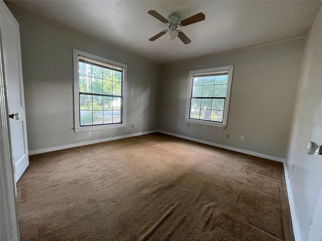 carpeted empty room featuring baseboards, ornamental molding, and ceiling fan