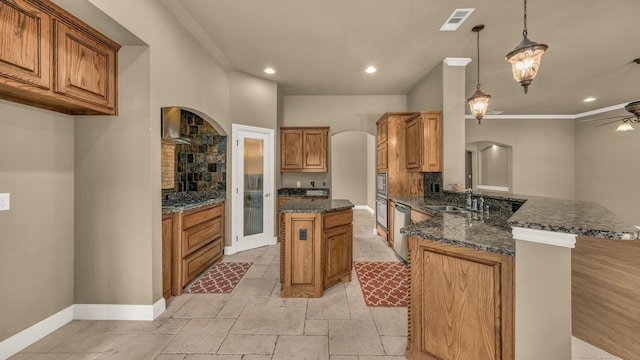 kitchen with a sink, arched walkways, tasteful backsplash, and a peninsula