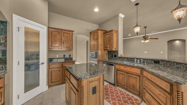 kitchen featuring a ceiling fan, a sink, a kitchen island, arched walkways, and stainless steel appliances