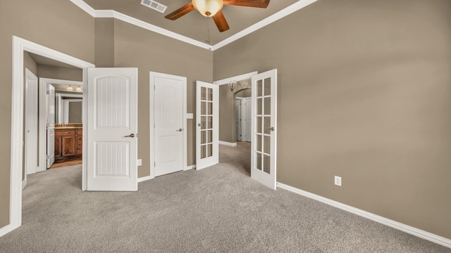 unfurnished bedroom featuring french doors, visible vents, crown molding, light colored carpet, and baseboards