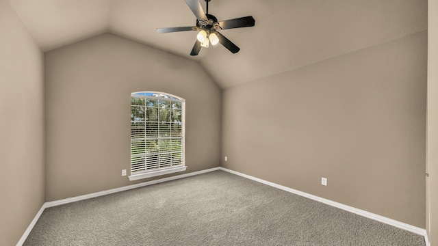 carpeted spare room featuring a ceiling fan, baseboards, and vaulted ceiling
