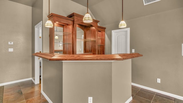 kitchen featuring dark tile patterned floors, decorative light fixtures, visible vents, and baseboards