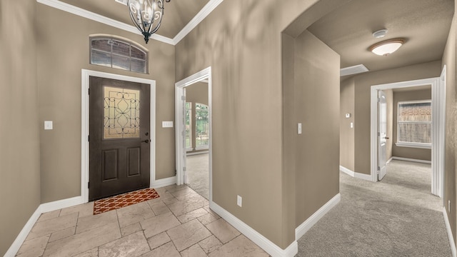 entryway with crown molding, arched walkways, baseboards, and stone tile flooring