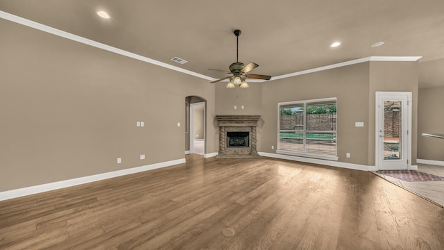 unfurnished living room with visible vents, crown molding, wood finished floors, baseboards, and a ceiling fan