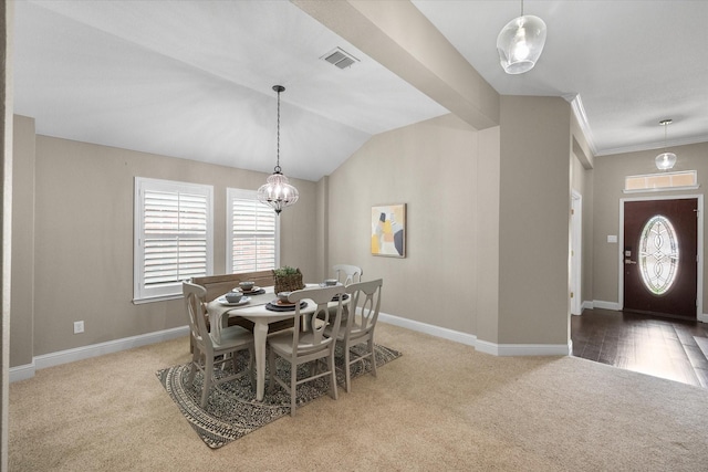 carpeted dining room featuring baseboards, a notable chandelier, lofted ceiling, and visible vents