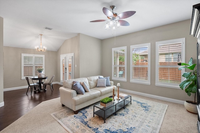 living area featuring baseboards, visible vents, plenty of natural light, and ceiling fan with notable chandelier