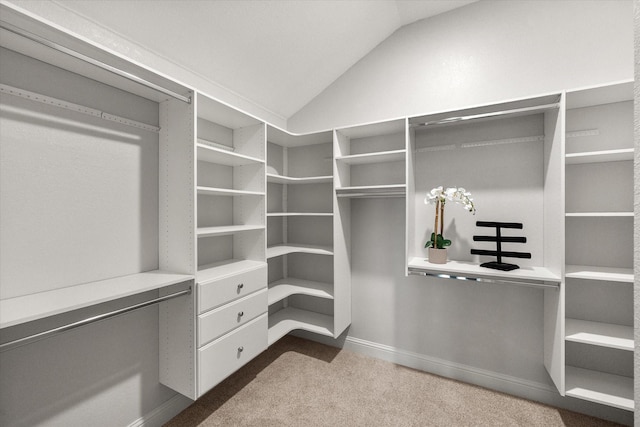 walk in closet with dark carpet and lofted ceiling