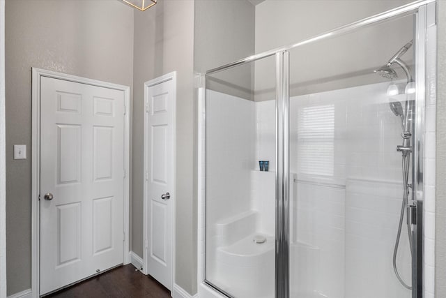 full bathroom with a shower stall and wood finished floors