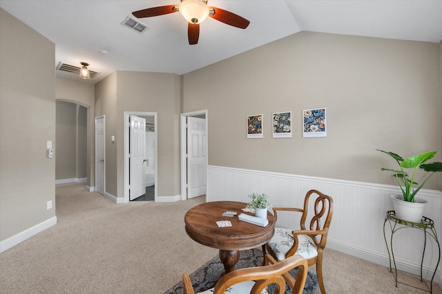 dining space featuring visible vents, wainscoting, light carpet, ceiling fan, and vaulted ceiling