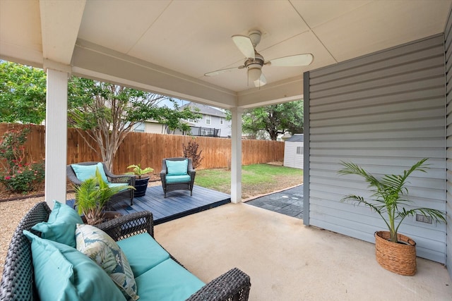view of patio with ceiling fan, a fenced backyard, an outdoor living space, a storage shed, and an outbuilding