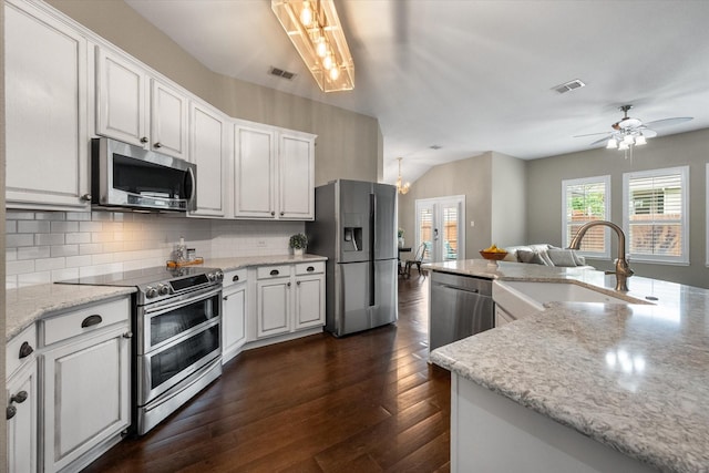kitchen with a sink, tasteful backsplash, stainless steel appliances, and visible vents