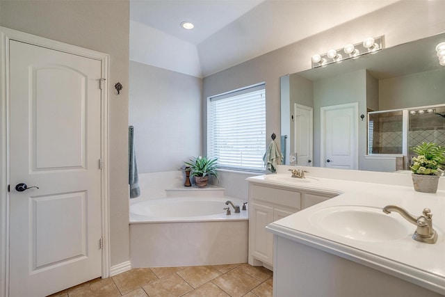 full bathroom featuring a sink, double vanity, a shower stall, and a garden tub