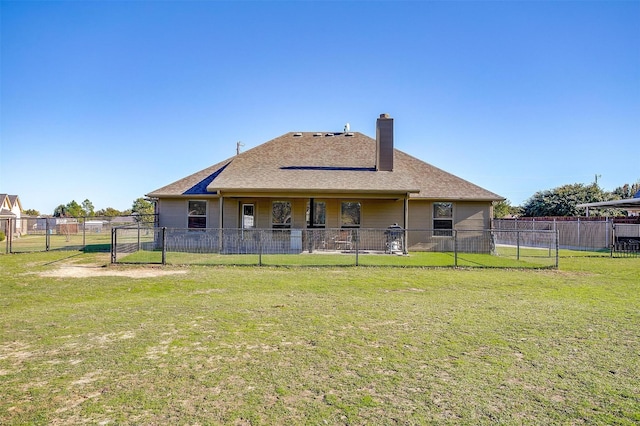 back of property featuring a lawn, a chimney, a gate, and a fenced backyard