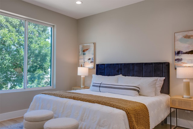 bedroom featuring recessed lighting, baseboards, multiple windows, and wood finished floors