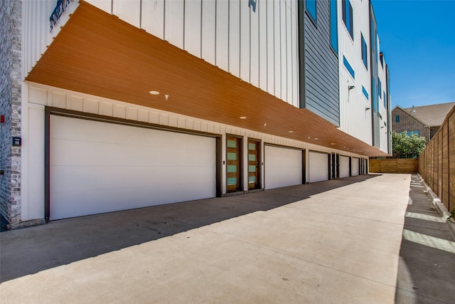 garage with fence and driveway