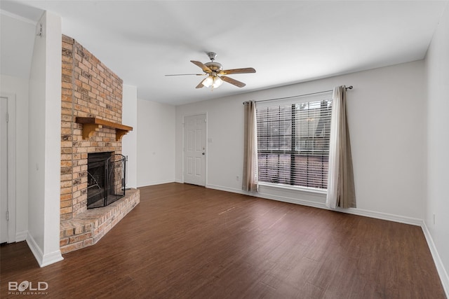 unfurnished living room featuring baseboards, ceiling fan, a brick fireplace, and dark wood finished floors
