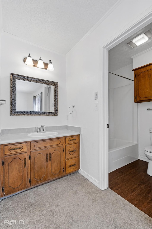 bathroom with crown molding, vanity, baseboards, toilet, and shower / bathtub combination
