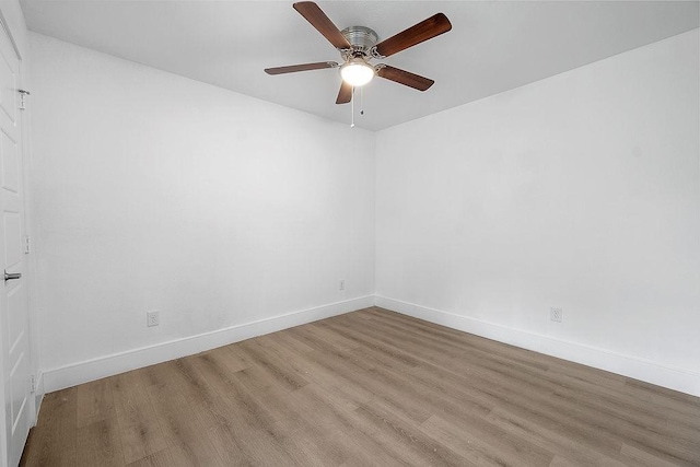 spare room with a ceiling fan, baseboards, and light wood-style floors