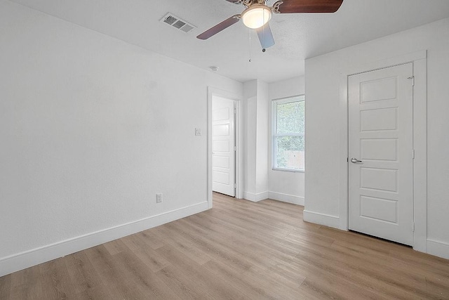 unfurnished bedroom with baseboards, a ceiling fan, light wood finished floors, and visible vents