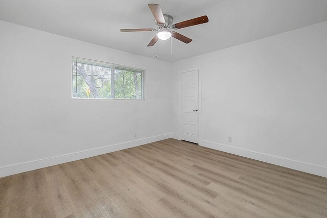spare room with a ceiling fan, baseboards, and light wood-type flooring