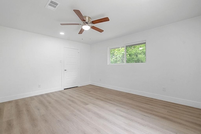 spare room with visible vents, a ceiling fan, baseboards, and wood finished floors