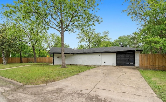 view of side of home featuring a yard, an attached garage, and fence