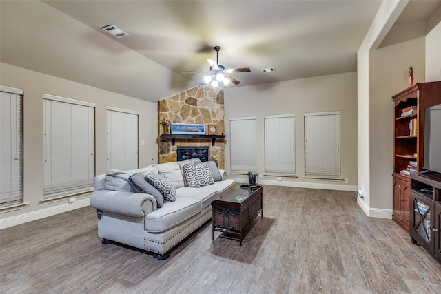 living room featuring baseboards, a ceiling fan, wood finished floors, and vaulted ceiling