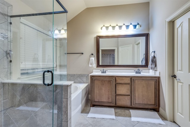 bathroom featuring vaulted ceiling, a shower stall, a sink, and a garden tub