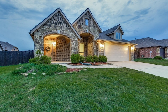 view of front of house featuring fence, a front yard, driveway, and stone siding