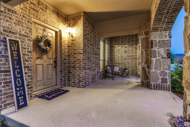 entrance to property with brick siding and covered porch