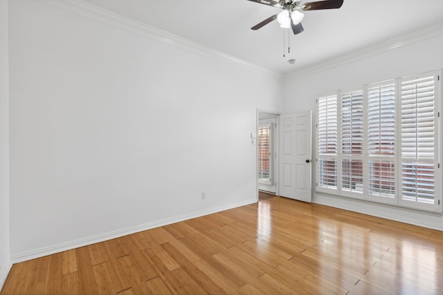 empty room featuring crown molding, baseboards, a ceiling fan, and light wood-type flooring