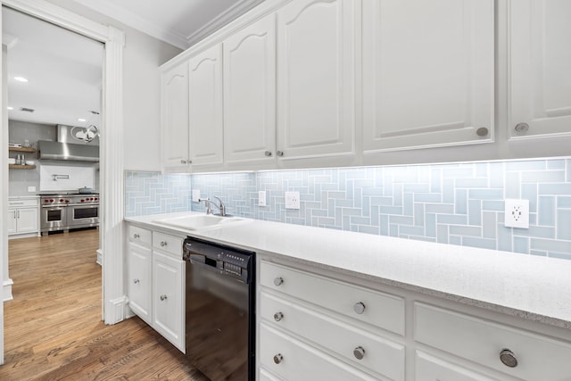 kitchen featuring white cabinets, a sink, black dishwasher, range with two ovens, and decorative backsplash