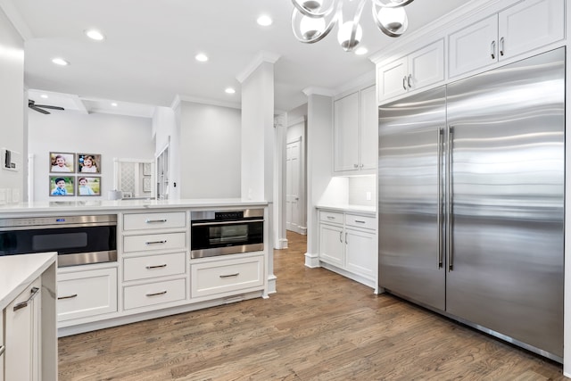 kitchen featuring white cabinetry, light countertops, stainless steel appliances, recessed lighting, and light wood-style flooring
